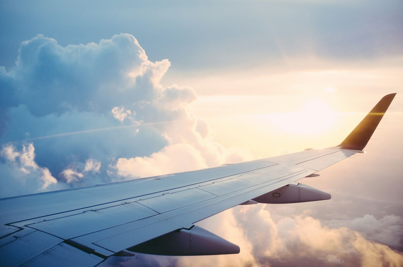 View from an airplane window over the clouds at sunset